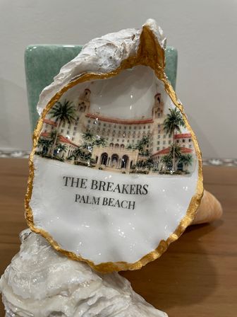 Gold-trimmed souvenir oyster shell with painted Palm Beach resort illustration and palm trees