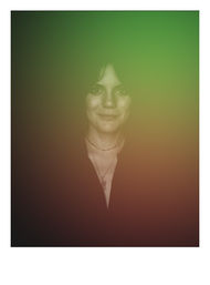 Moody vintage headshot of a smiling woman with layered necklaces and a V‑neck top, softened by a green-to-brown gradient overlay and subtle vignette.