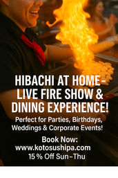 Smiling hibachi chef in black shirt and red neckerchief ignites a towering flame over a flat grill of shrimp during a lively at-home teppanyaki fire show and dining experience