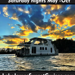 Houseboat on a lake at a dramatic golden sunset with fiery clouds and shimmering water