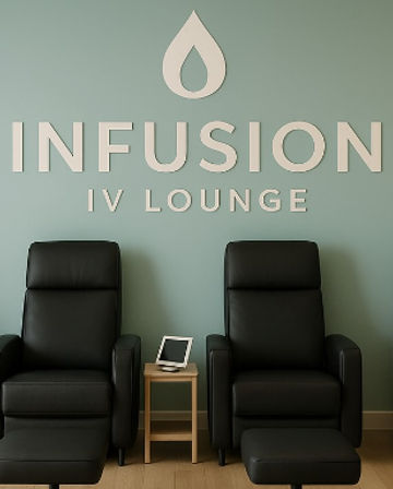 Two black leather recliners with footrests against a muted green wall with IV lounge signage, small wooden side table holding a tablet, modern, cozy IV therapy wellness clinic interior.