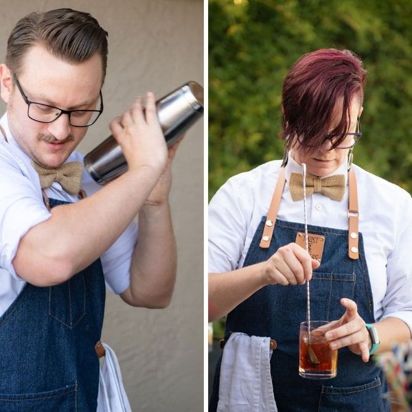Split image of two craft bartenders in denim aprons and bow ties — left shaking a metal cocktail shaker, right stirring a cocktail in a rocks glass with a long bar spoon outdoors.