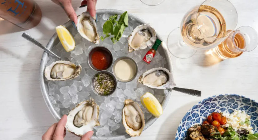 Briny oysters on the half shell on crushed ice with lemon wedges, cocktail sauce, mignonette and Tabasco, paired with rosé and a side salad.