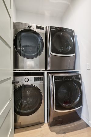 Sleek stacked stainless-steel front-load washer and dryer sets in a compact white laundry closet
