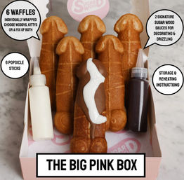 Pink gift box with six novelty penis-shaped waffle pops on sticks, one dipped in chocolate with white drizzle, plus two squeeze-sauce bottles for decorating.