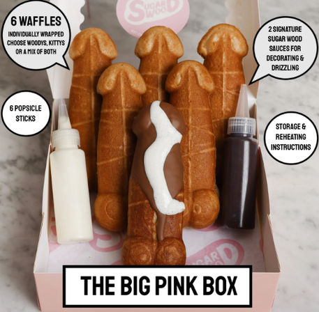 Pink gift box with six novelty penis-shaped waffle pops on sticks, one dipped in chocolate with white drizzle, plus two squeeze-sauce bottles for decorating.