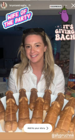 Smiling woman at a home bachelorette party holding a plate of novelty penis-shaped pastries with playful stickers and an eggplant graphic