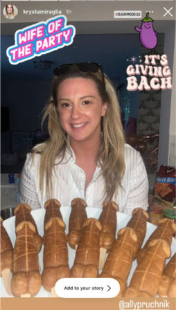 Smiling woman in a home kitchen at a bachelorette party holding a platter of novelty penis-shaped pastries, with stickers reading “Wife of the Party” and “It’s Giving Bach” and an eggplant emoji.