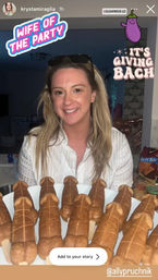 Smiling woman in a kitchen holding a plate of novelty penis-shaped cake pops on sticks at a bachelorette-style party, with playful stickers reading “Wife of the Party” and “It’s Giving Bach”.