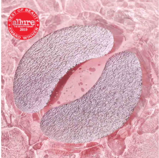 Sparkly pink crescent under-eye hydrogel patches for skincare on a rippled pink water background with a red beauty-award badge
