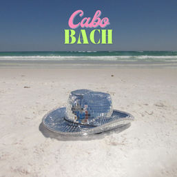 Disco mirror-tile cowboy hat resting on white-sand beach with turquoise waves and clear sky, neon "Cabo BACH" text above the horizon