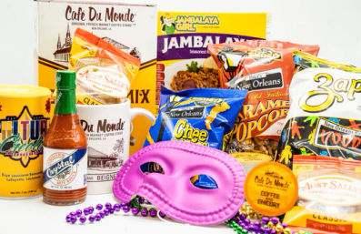 Vibrant New Orleans snack kit with Cajun treats and souvenirs: hot sauce, coffee, seasoned mixes, popcorn and chips, plus a pink Mardi Gras mask and purple-green beads