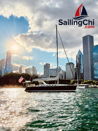 Sunlit sailboat flying an American flag on Lake Michigan with the Chicago skyline, sparkling water and dramatic clouds at golden hour