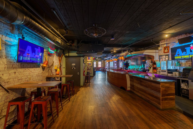 Cozy urban bar interior with a long wooden counter, glowing neon signs, hanging globe lights, high-top tables and metal stools