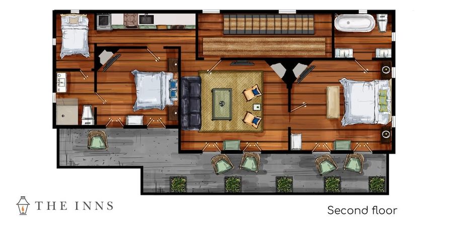 Top-down floor plan of a second-floor suite showing three bedrooms, a central living room with sofa and chairs, a small kitchenette, a full bathroom with bathtub and double sinks, stairs and a wide front balcony with wicker seating and potted greenery; warm wood floors throughout.