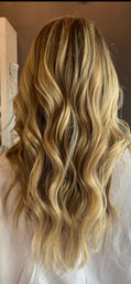 Back view of long sun-kissed blonde balayage hair with loose beachy waves, salon-style finish.