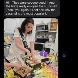 Bride-to-be wearing a white sash and veil slicing assorted pastries from bakery boxes on a gold-covered kitchen table during a bachelorette party, with purple cups, snacks and a modern oven and microwave in the background.