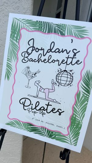 Bachelorette pilates pop-up event sign on an easel with tropical palm-leaf border, pink scalloped frame and playful pilates illustrations and disco ball, displayed outside by a doorway