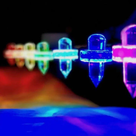 Close-up of sparkling multicolored LED string lights with crystal-shaped bulbs and colorful bokeh glow against a dark background, festive night decor