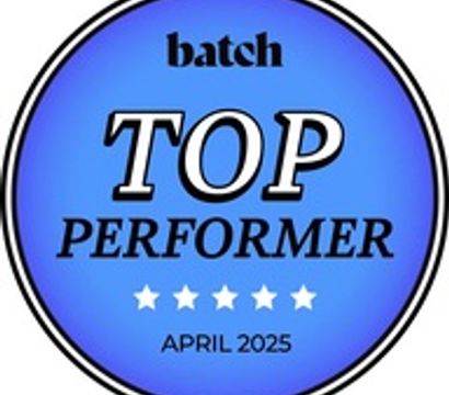 Circular blue award badge reading "TOP PERFORMER" with five white stars and the date "April 2025"