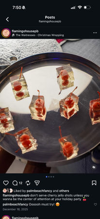 Clear gelatin jello shots with maraschino cherries on stems arranged on a round silver serving tray — a festive holiday party appetizer.