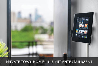 Wall-mounted tablet streaming music in a private townhome living area with balcony and blurred urban skyline view