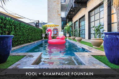 Modern urban courtyard with a narrow rectangular pool, a bright pink flamingo float, potted tropical plants, yellow-striped umbrella and stone building facade