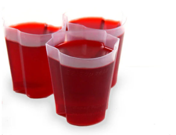 Three clear plastic shot cups filled with bright red gelatin, arranged closely on a white background.