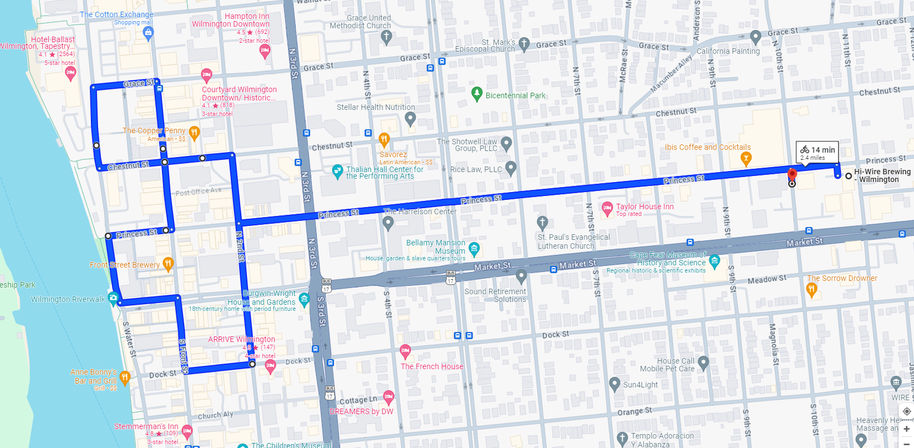 Blue bike route map of downtown Wilmington, NC — looping along Cape Fear riverfront streets then heading east on Princess Street across historic downtown, about 2.4 miles (≈14 min).