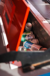 Red-lidded metal cooler packed with ice and chilled aluminum cans, featuring a lime margarita can among assorted canned drinks