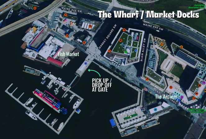 Annotated aerial map of a waterfront wharf and market docks showing marina piers with moored boats, waterfront promenade and buildings, with an arrow highlighting a pickup/drop-off gate.