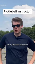 Person in sunglasses and navy shirt standing on an outdoor pickleball court with overlaid captions reading "Pickleball Instructor:" and "I'm a pickleball instructor", trees and blue sky behind.