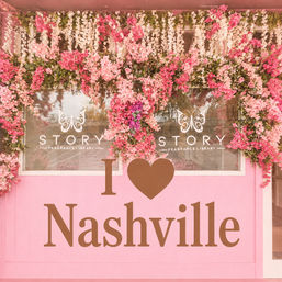 Pink storefront adorned with cascading pink and white flower garlands around windows and a large "I ♥ Nashville" sign on the facade
