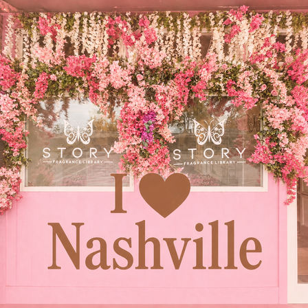 Pink storefront adorned with cascading pink and white flower garlands around windows and a large "I ♥ Nashville" sign on the facade