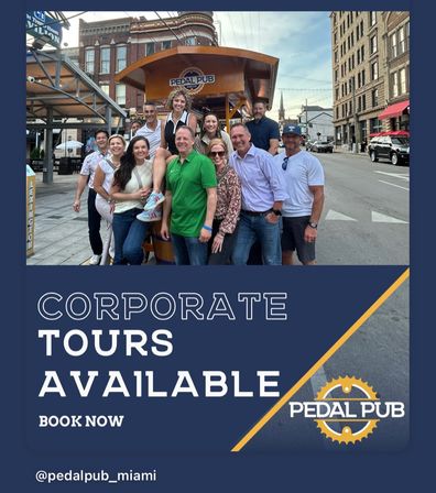 Smiling group of coworkers posing on a pedal-powered party bike parked on a downtown street with brick buildings, promotional graphic advertising corporate tours.
