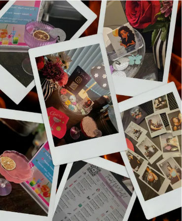 Polaroid-style collage showing a cocktail bar tabletop display with colorful mocktails garnished with citrus, a striped vase of flowers, scattered photo prints and coasters, and a QR-coded drink menu — Instagram-ready bar scene.
