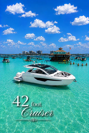 White 42-foot cruiser anchored in crystal-clear turquoise water near a lively sandbar with a floating tiki bar and dozens of boats under a bright blue sky
