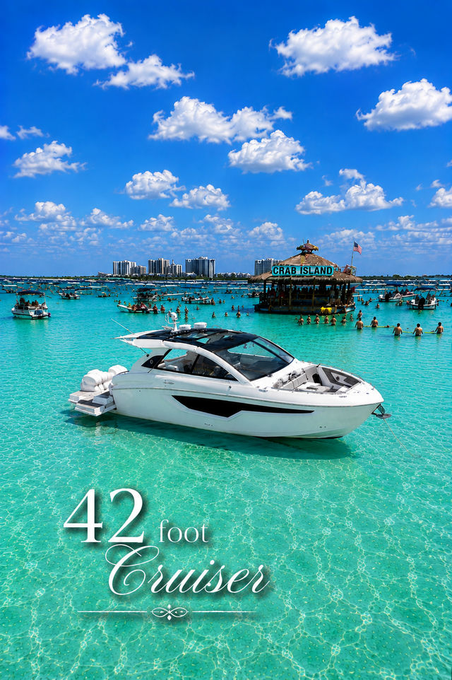 White 42-foot cruiser anchored in crystal-clear turquoise water near a lively sandbar with a floating tiki bar and dozens of boats under a bright blue sky