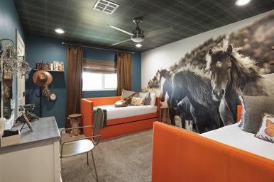 Ranch-themed kids' bedroom with bright orange twin daybeds, oversized black-and-white horse mural, teal walls, plaid ceiling, ceiling fan and rustic western accents