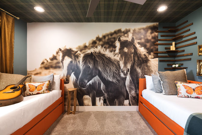 Cozy modern rustic bedroom with a large black-and-white horse mural behind two orange twin daybeds, butterfly throw pillows, an acoustic guitar on the left bed, wood accent shelves and warm recessed lighting.