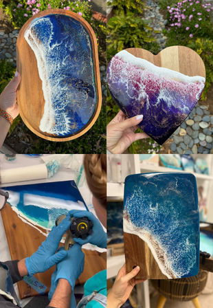 Collage of four photos showing handmade epoxy resin ocean wave art on wooden boards — vibrant blue and purple foamy surf effects on oval, heart-shaped and rectangular serving boards, plus a close-up of gloved hands torching resin in a studio with a garden pebble background.
