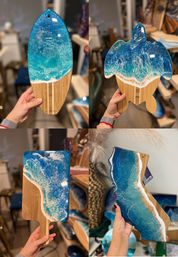 Collage of four handmade bamboo serving boards with ocean epoxy resin art — surfboard, sea turtle, paddle and California-shaped board — vivid turquoise-to-deep-blue waves, white foam and sandy shoreline details, held in a craft studio.