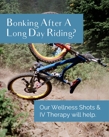 Mountain bike flipping on a dusty forest trail with pine trees in the background, overlaid text reads: Bonking After A Long Day Riding? Our Wellness Shots & IV Therapy will help.