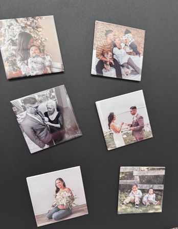 Seven square custom photo magnets on a black background showing family scenes: holiday mom with infant, parents with baby and pets, grayscale groom with older woman, wedding couple exchanging rings, pregnant woman with bouquet, and two toddlers outdoors.