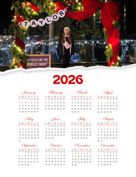 Person in a winter coat and beanie posing under a large festive wreath arch with red ribbon, ornaments and twinkling lights at an outdoor nighttime holiday display, framed above a 2026 calendar layout