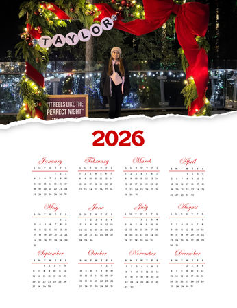 Person in a winter coat and beanie posing under a large festive wreath arch with red ribbon, ornaments and twinkling lights at an outdoor nighttime holiday display, framed above a 2026 calendar layout