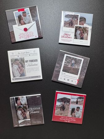Flat-lay of six Valentine's-themed photo tiles on a dark tabletop featuring a couple's beach photos and romantic captions like "Happy Valentines" and "My Forever Valentine" — stylish Valentine's Day gift idea.