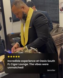Bearded man in a black suit with a yellow lapel preparing a cigar in an upscale South Florida cigar lounge interior.