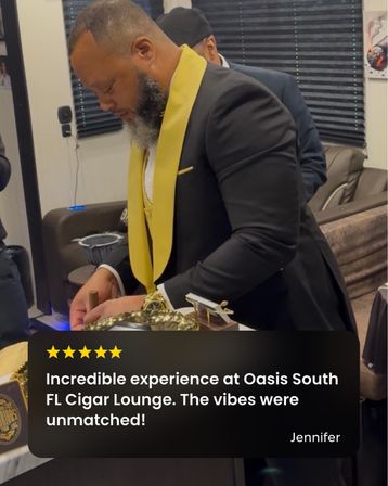 Bearded man in a black suit with a yellow lapel preparing a cigar in an upscale South Florida cigar lounge interior.