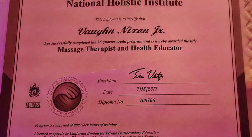 Pink diploma certificate for a massage therapist and health educator from a holistic training program, with an official seal, signature, and July 2017 date.